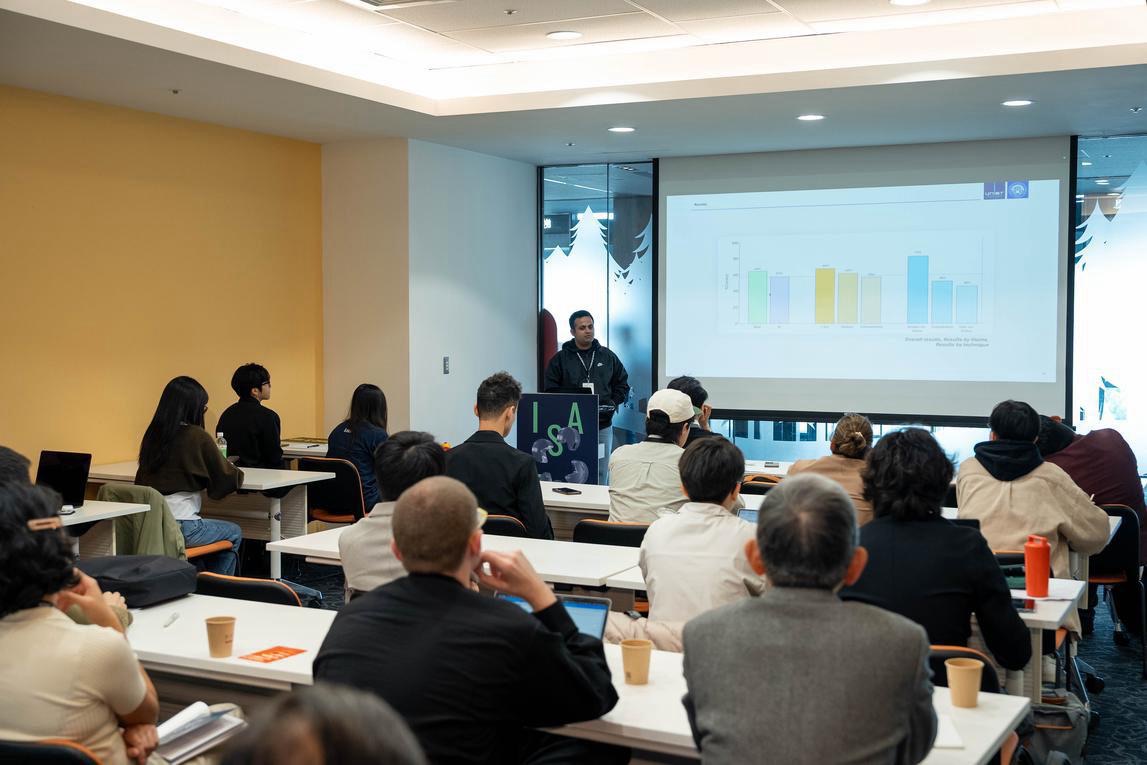 An audience in a conference room watching a presentation of the study’s accuracy chart